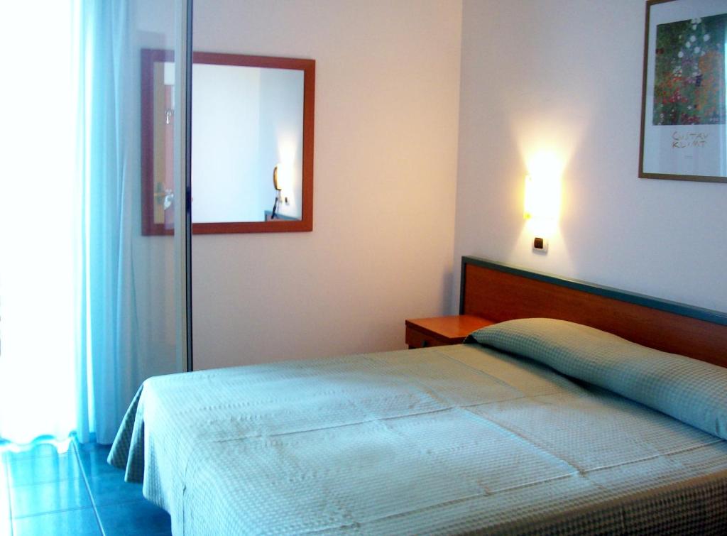 um quarto com uma cama e um espelho na parede em Hotel Sole em Giulianova