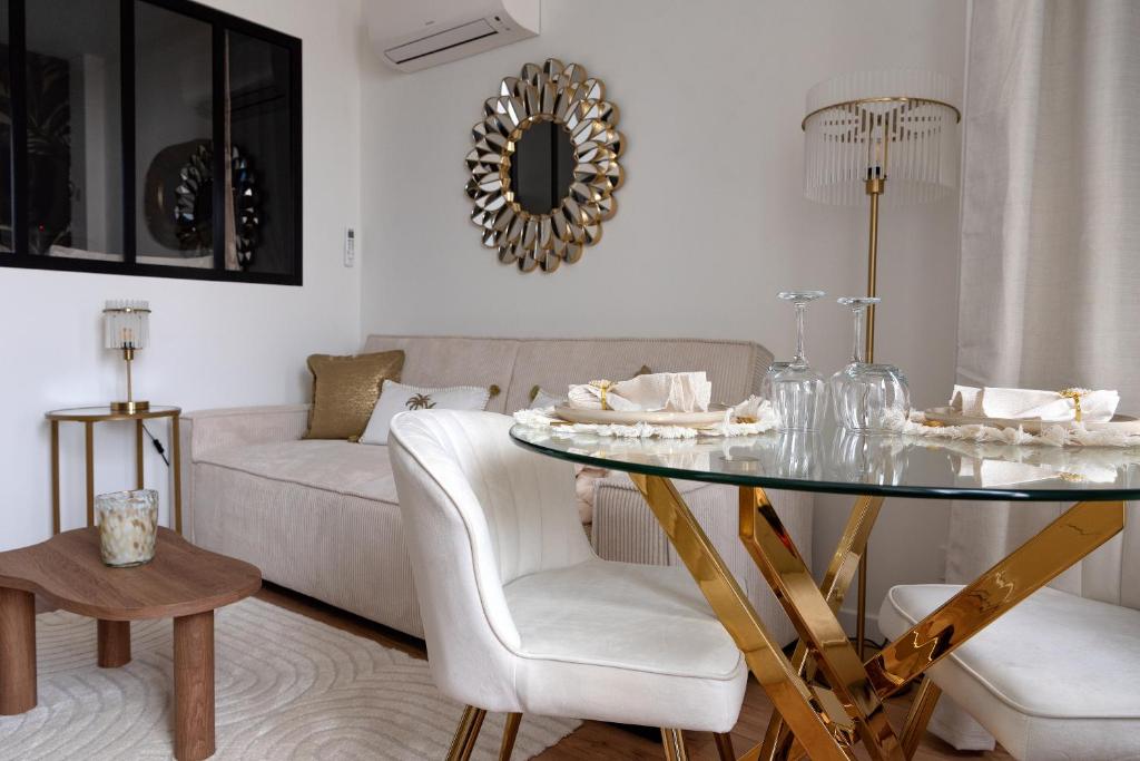 a living room with a glass table and a couch at Les Nuits en Grands Crus Coocon et soins Occitane in Ladoix Serrigny