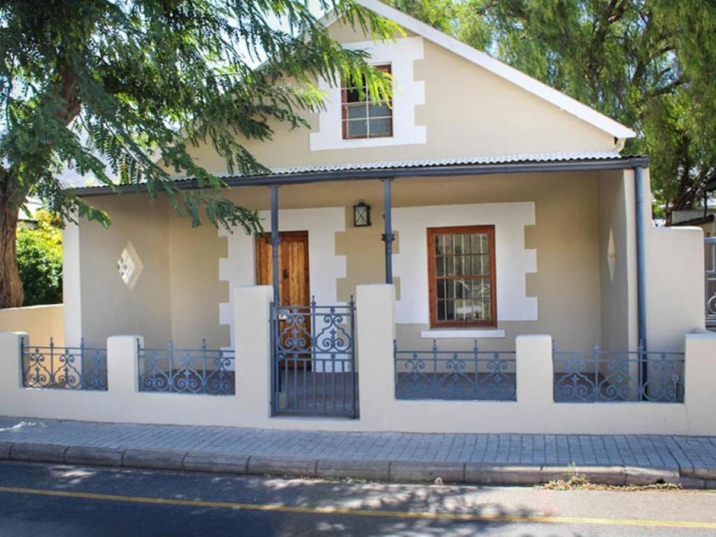 a small white house with a black fence at The Luxury Loft in Montagu