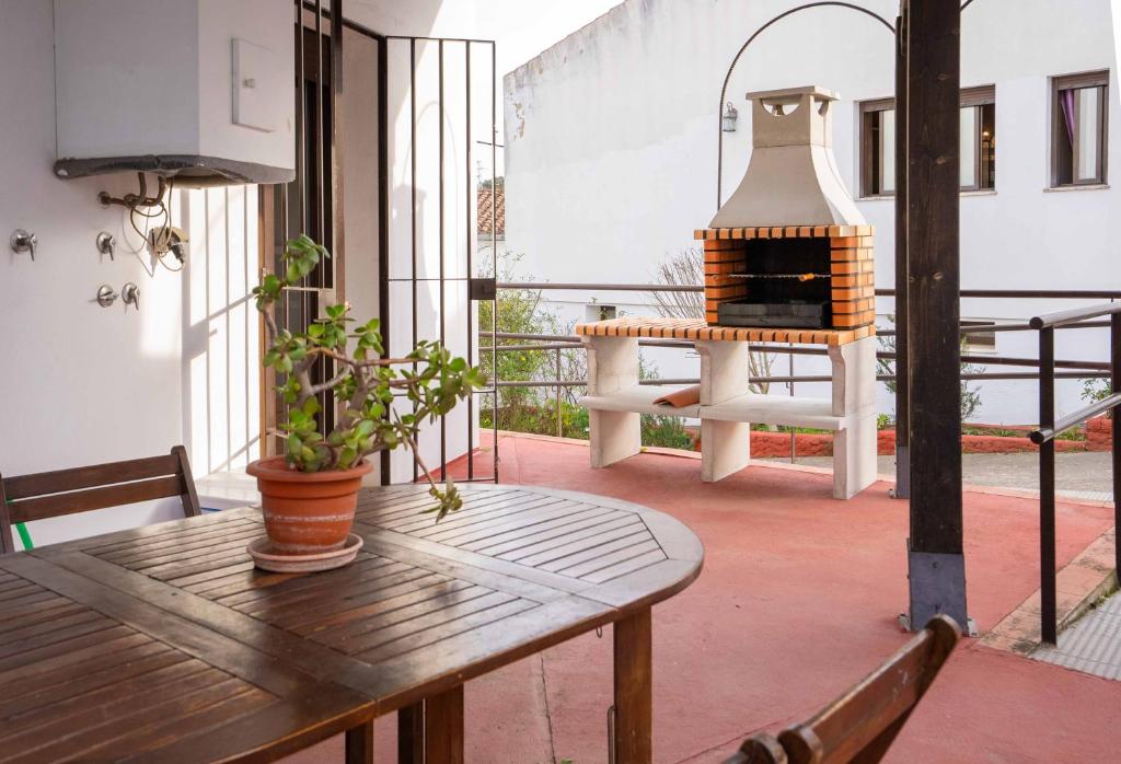 a patio with a table and a fireplace on a balcony at Casas Rurales Los Montes in La Corte