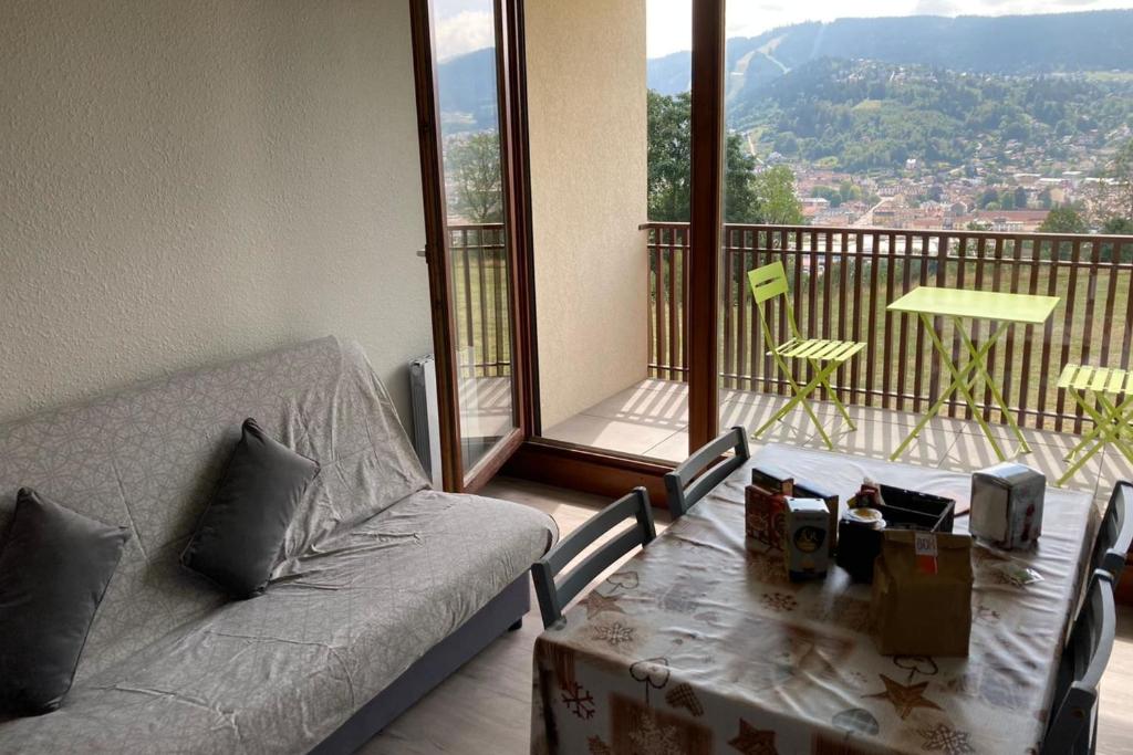 Una sala de estar con un sofá y una mesa y un balcón. en Apartment With Balcony In Gérardmer, en Gérardmer