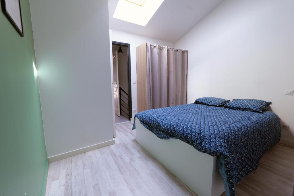 a bedroom with a bed with a blue comforter at Duplex cosy centre historique 2 ch 3 lits linge serviettes inclus 5 pers tout à pied in Le Puy en Velay