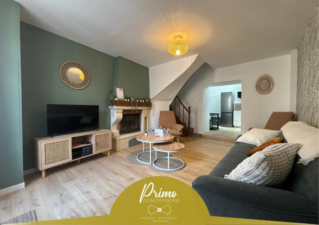 a living room with a couch and a tv at La Maison D'isaure 6 personnes Parthenay centre in Parthenay