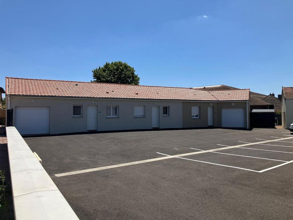 een gebouw met een parkeerplaats ervoor bij Échappée Loire in Saint-Nizier-sous-Charlieu