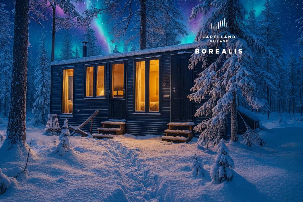 una cabaña en el bosque en la nieve en Lapelland Village - Borealis Village with a Nature View, Fireplace, Sauna, Kitchen, en Äkäslompolo