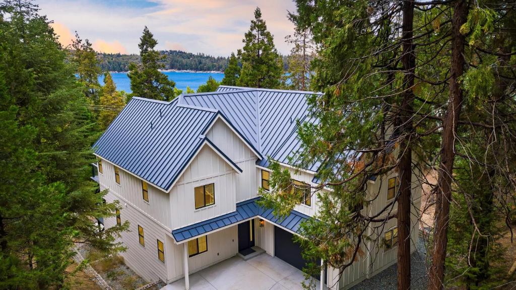 eine Luftansicht eines Hauses mit blauem Dach in der Unterkunft Luxury Retreat 5mins to the Lake Game Room Fire Pit Howlite by AvantStay in Lake Arrowhead