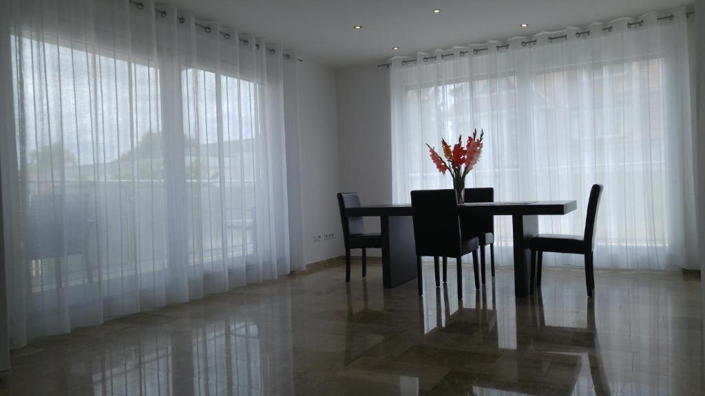 a dining room with a table and chairs and white curtains at Zimmervermietung im Zentrum Waiblingens in Waiblingen