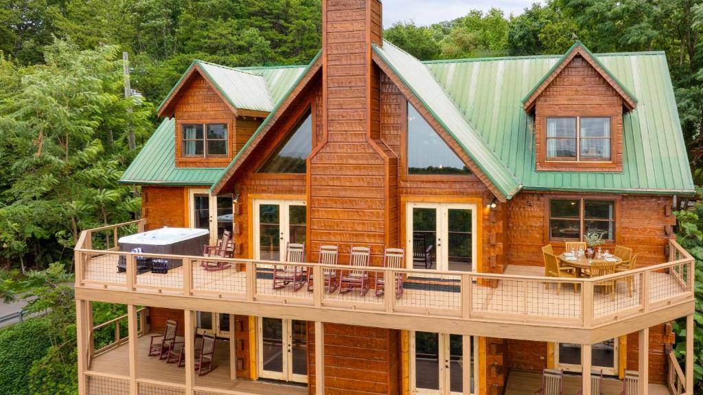 ein Haus mit einer umlaufenden Terrasse mit Gründach in der Unterkunft Big Bear Lodge by AvantStay Smoky Mountain Views Hot Tub Theater Game Room in Sevierville