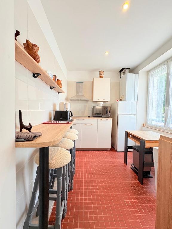 a kitchen with a table and some chairs in a room at Anglet - T3 en duplex récemment rénové in Anglet