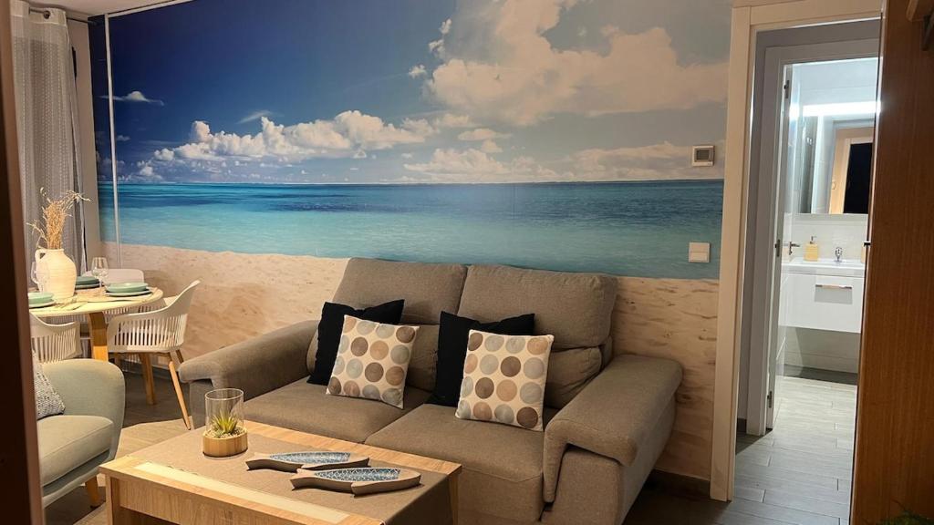 una sala de estar con una pintura del océano en Teatinos Int Apartment, en Málaga