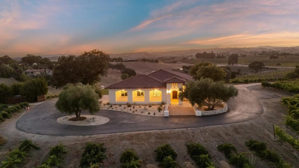 an aerial view of a house with a sunset at Wine Country Escape w Views Wine Cellar Gym Caterina Dusi Vineyard by AvantStay in Paso Robles