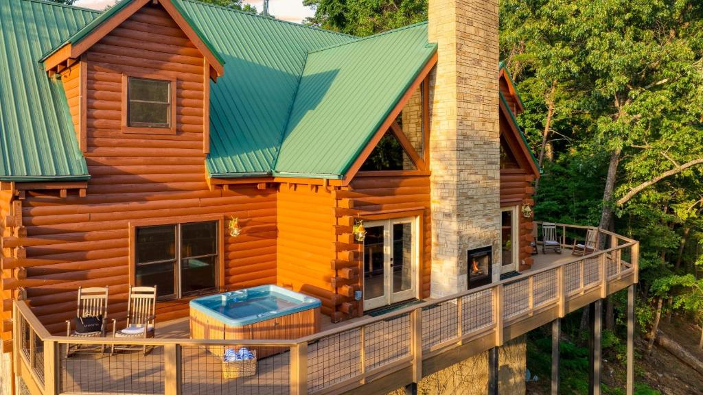 eine Blockhütte mit Terrasse und Whirlpool in der Unterkunft Big Bear Cove by AvantStay Hot Tub Game Room Fireplace Smoky Mtn Views in Sevierville