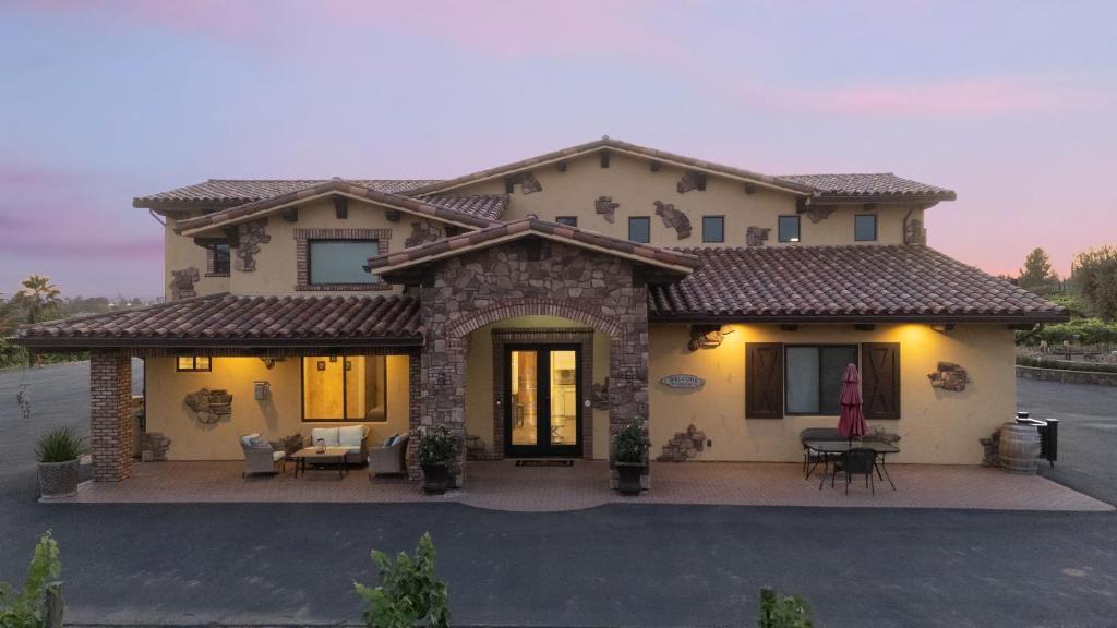 a house with a patio in front of it at New-Build Temecula Villa with King Suite Fireplace Vineyard Views The Villa by AvantStay in Temecula