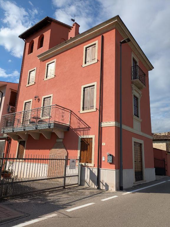 a large red brick building with a balcony at La Finestra Sul Castello in Soave