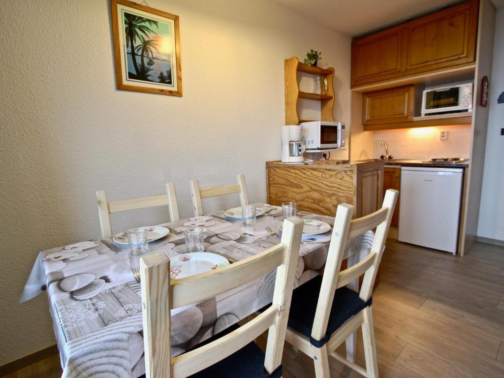 un tavolo da pranzo con sedie e una cucina di Studio avec parking couvert à Chamrousse - FR-1-340-61 a Chamrousse