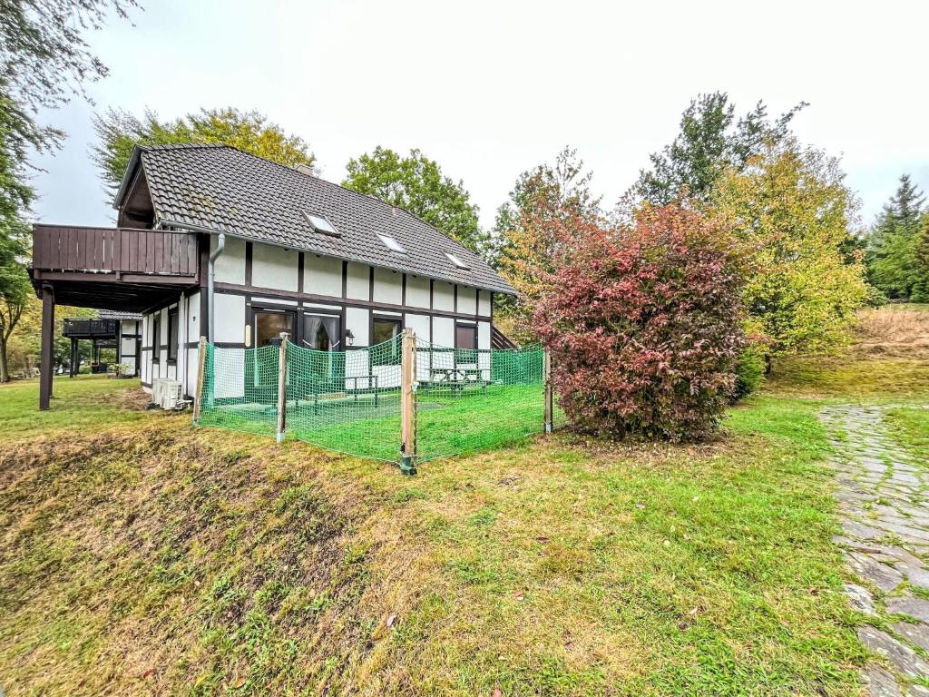 une maison sur une colline avec une clôture devant dans l'établissement Apartment Am Sternberg 230 by Interhome, à Frankenau