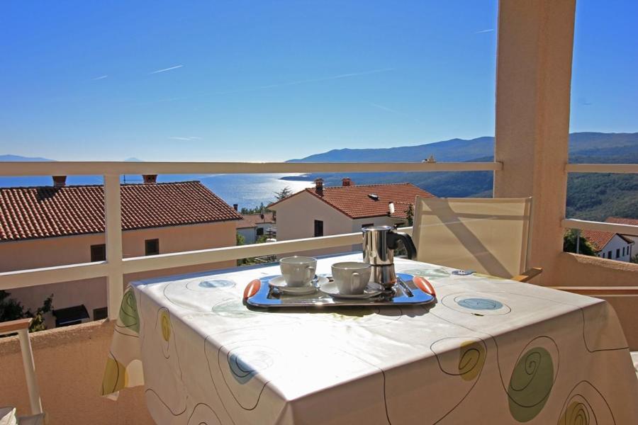 a table with a tea kettle on it on a balcony at Lemechi Casa Belfior Apartments in Rabac