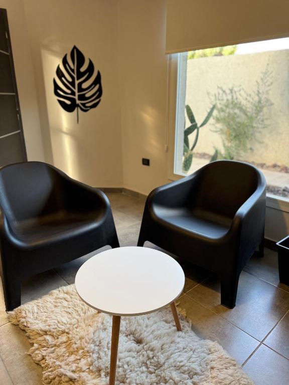 two black chairs and a table in a room at 3H MALARGUE Duplex calefacción por radiadores in Malargüe