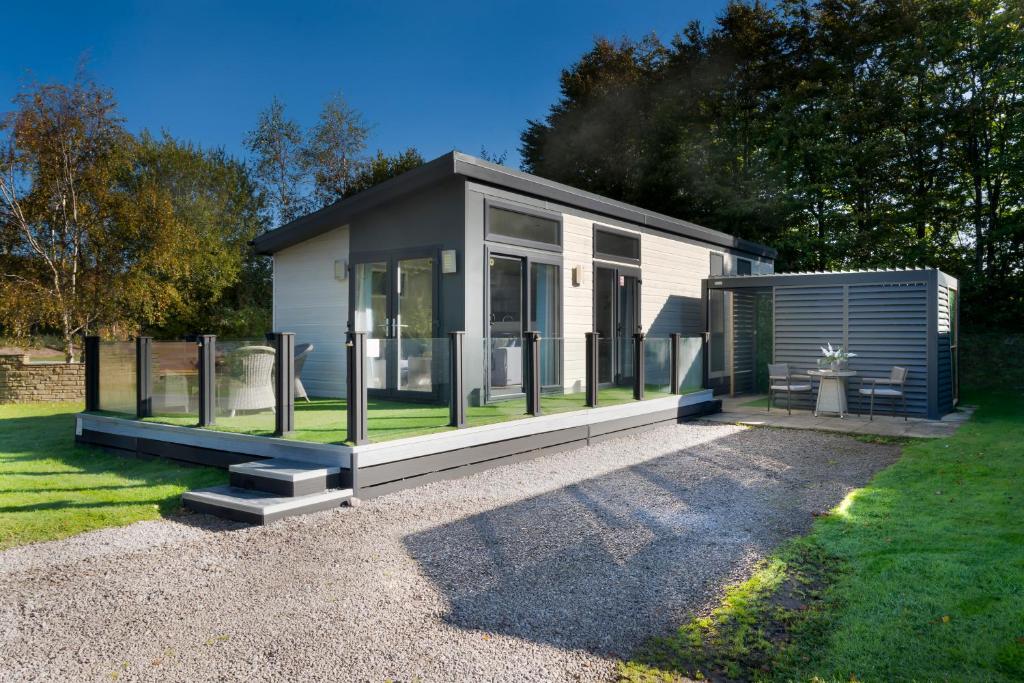 una casetta in bianco e nero in un giardino di Silverdale Lodge, HotTub, Wi-FI, Quiet & Sleeps 4 a Warton