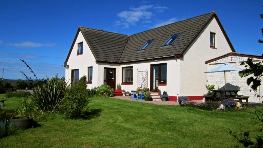 a white house with a black roof at Little Haven in Gairloch