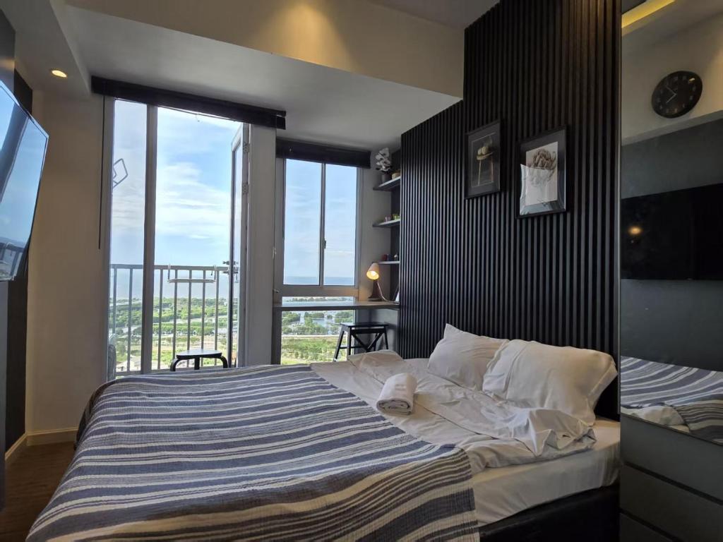 una camera da letto con un letto grande con una grande finestra di PIK2 Tokyo Riverside Apartment Studio a Muara