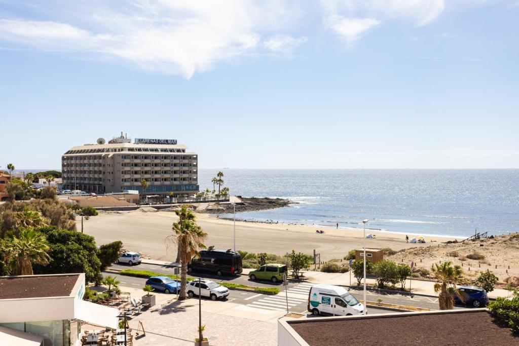 a view of a beach with a hotel and the ocean at Seafront Penthouse in El Medano in El Médano