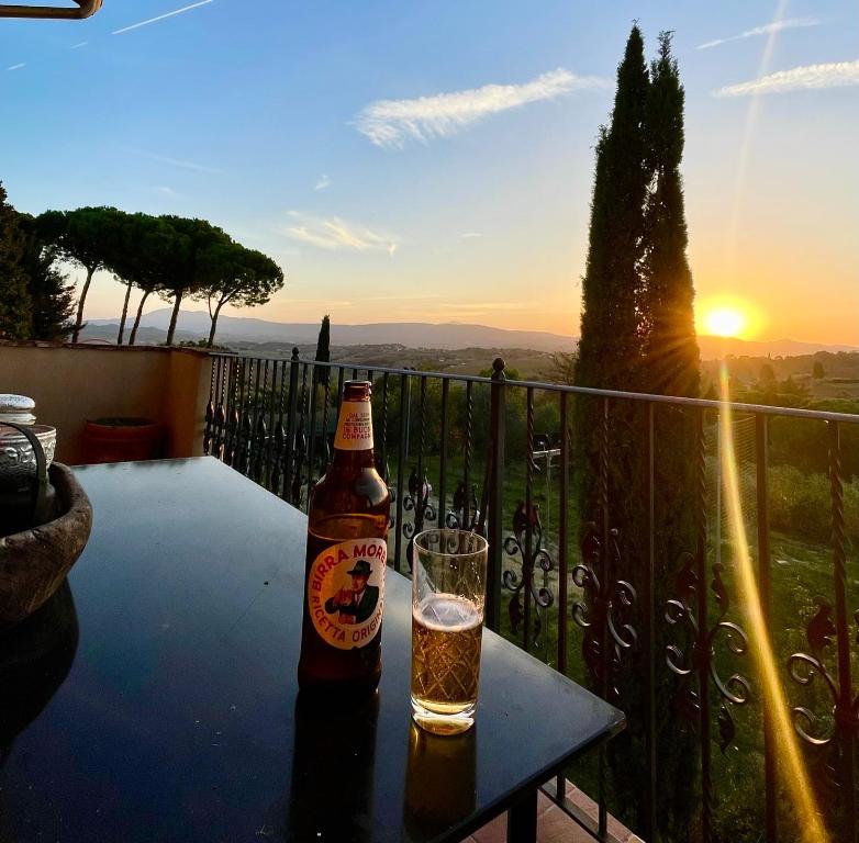 a bottle of beer sitting on a table with a glass at Spectacular Views from Private Apartment in a Local Umbrian Village in Gioiella