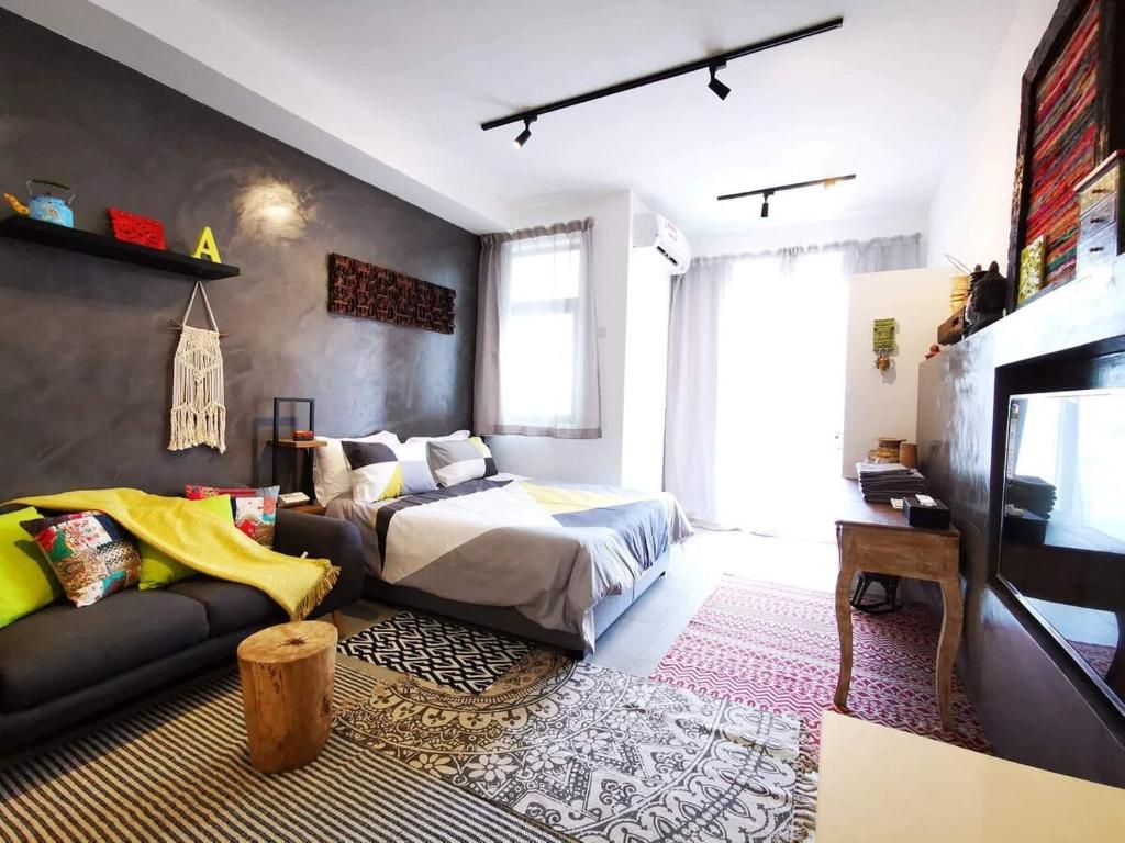 a bedroom with a bed and a couch at Studio 207 Ebene Square Apartments in Quatre Bornes