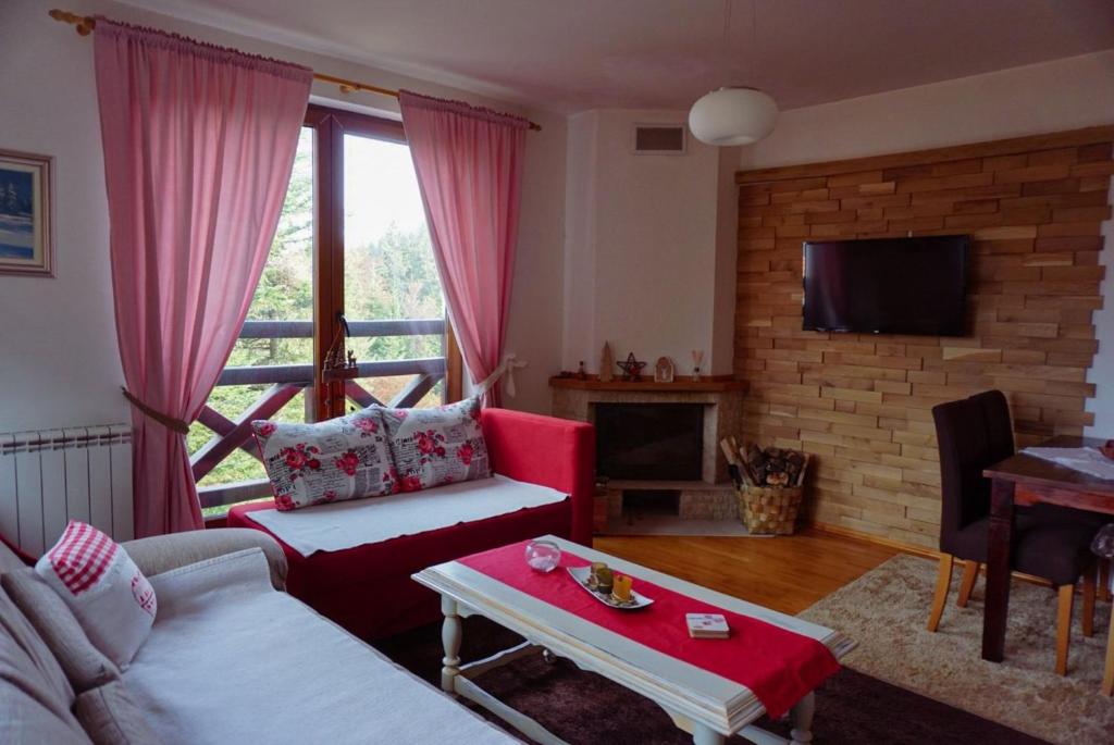 una sala de estar con un sofá y una mesa en Apartment Oganj, en Jahorina