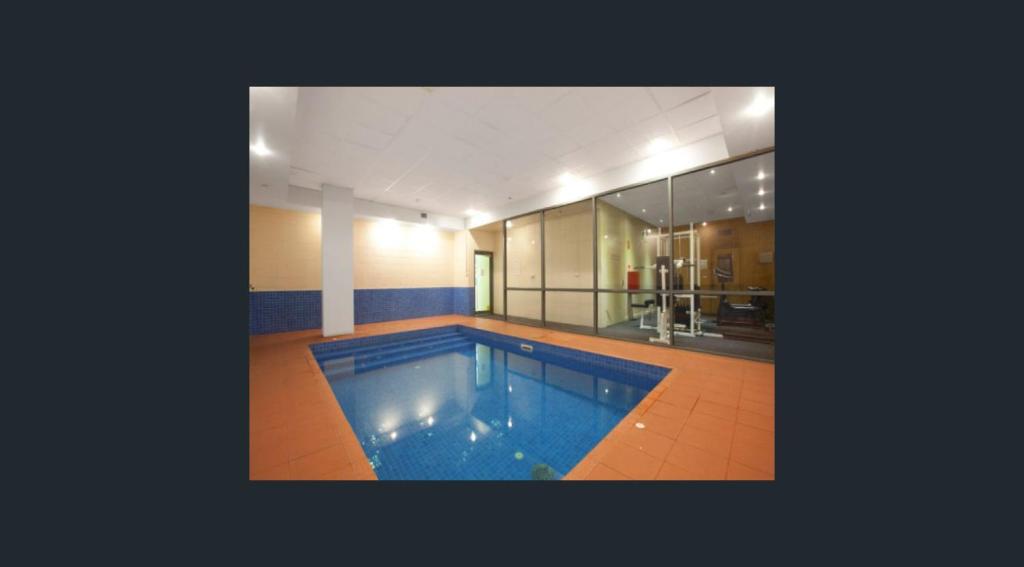 a large swimming pool in the middle of a house at Minimalist 2-Bed, 2-Bath Apartment in Melbourne CBD - Free Parking in Melbourne