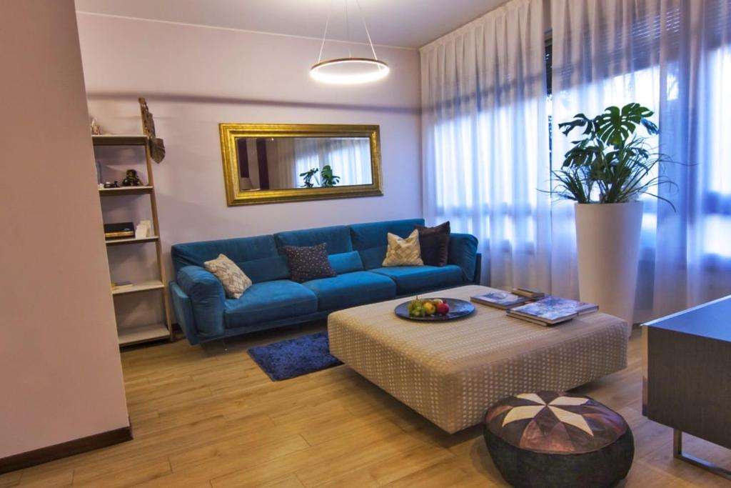 a living room with a blue couch and a table at Al Ventidue in Varese