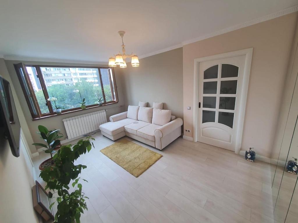 a living room with a white couch and a window at Apartament Lux in Bucharest