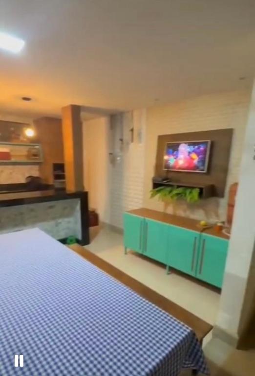 a room with a bed and a tv on a wall at Casa Sol & Mar Guriri in São Mateus