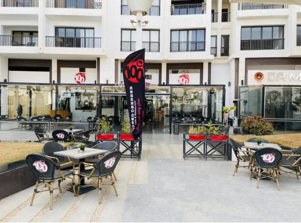 a restaurant with tables and chairs in front of a building at 90 New Cairo - Full Services Apartments in Cairo