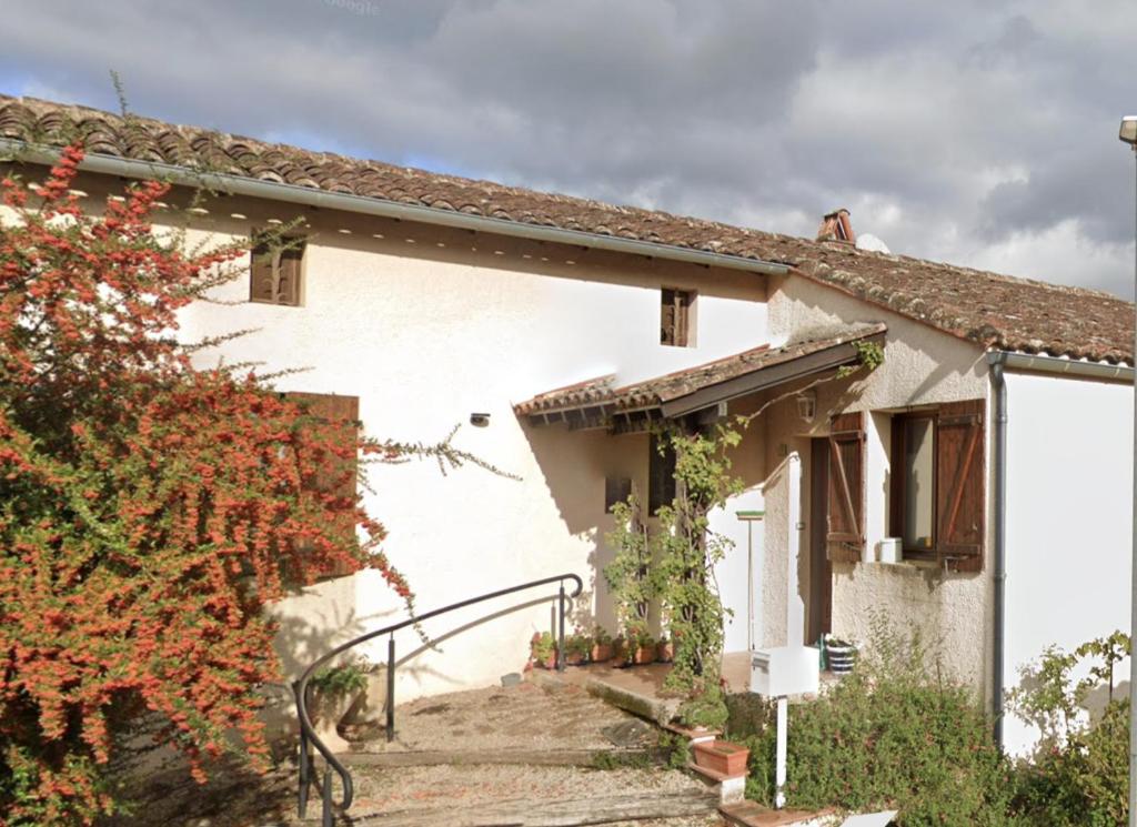 a white house with a stairway leading up to it at La jolie Vue et La Maison de la Tour- Cordes-sur-Ciel in Les Cabannes