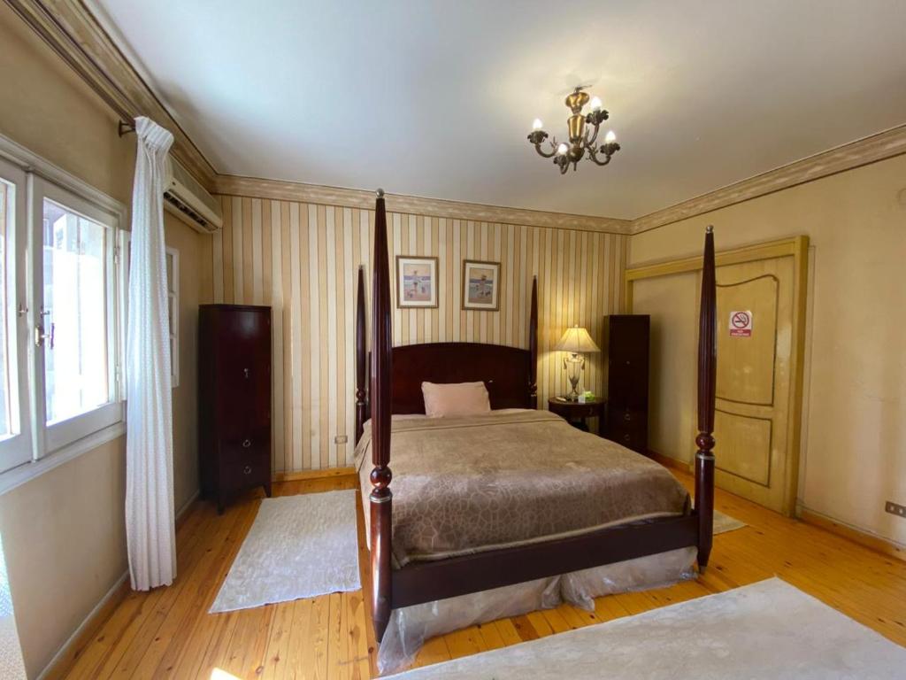 a bedroom with a bed and a chandelier at Imperial room in Cairo