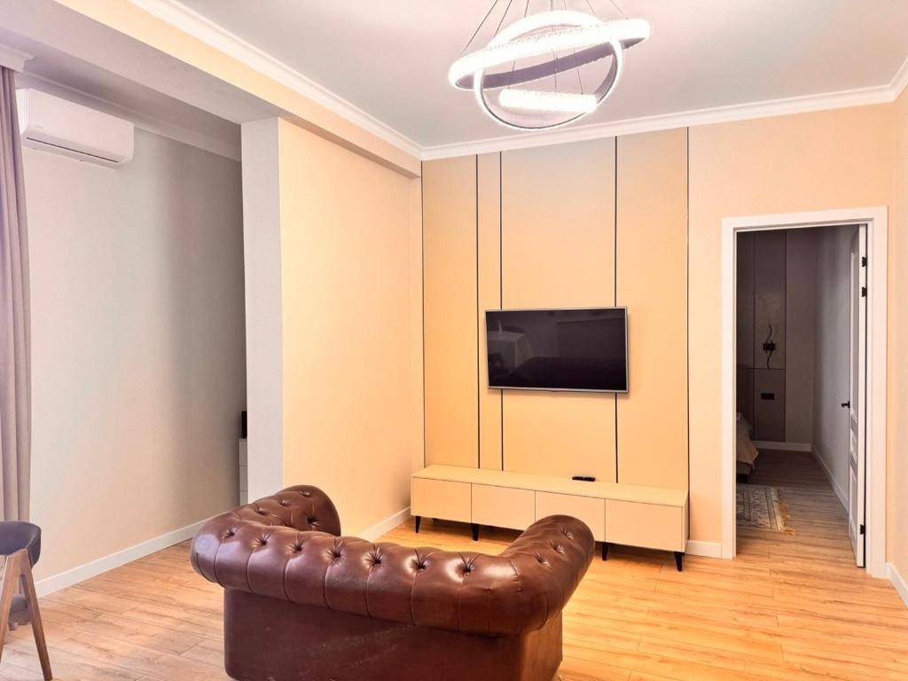 a living room with a couch and a television at Premium Delux Astana in Zhezdi