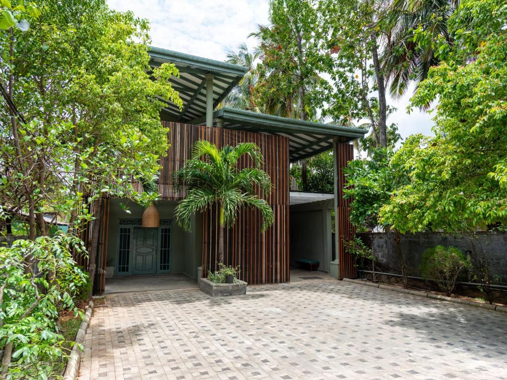 a house with a palm tree in front of it at Moi Dambulla by DBI in Dambulla