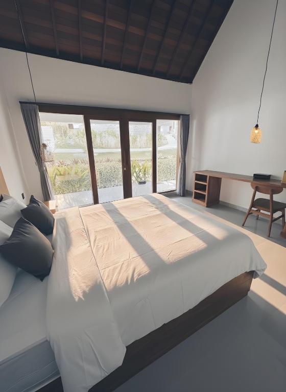 a bedroom with a large bed and a desk at Ginantary Cottages in Uluwatu