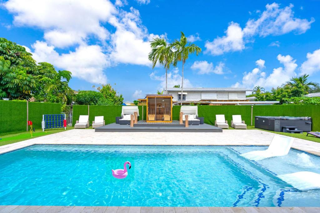 una piscina con un cisne rosa en el agua en Miami Resort Villa - Volleyball - Jacuzzi - Sauna, en Ives Estates