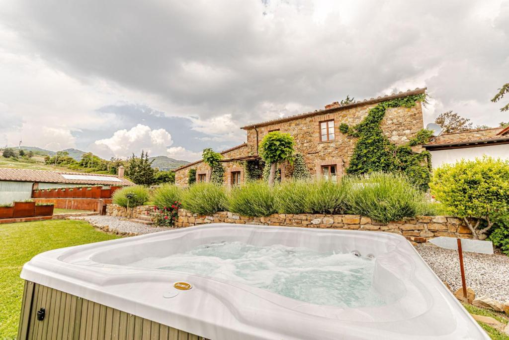 a bath tub in the yard of a house at Villa Cedri By Halldis in Montecatini Val di Cecina