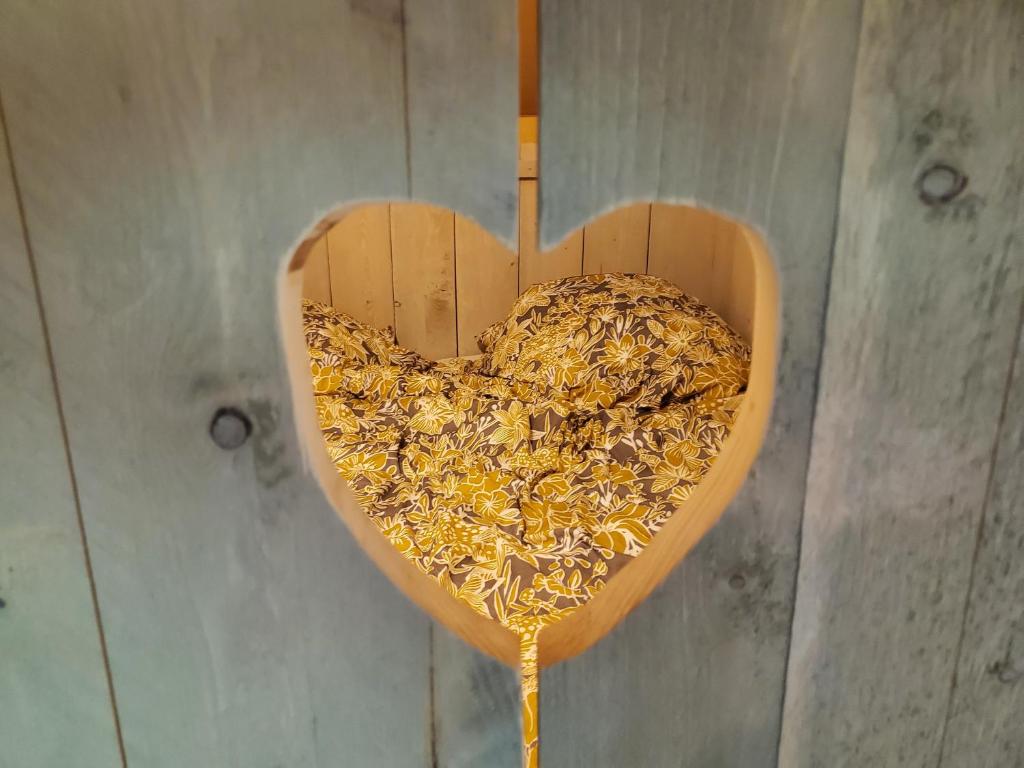 a wooden heart with a bunch of bees in it at Lodge à Folie Verte in Fontenay-le-Comte