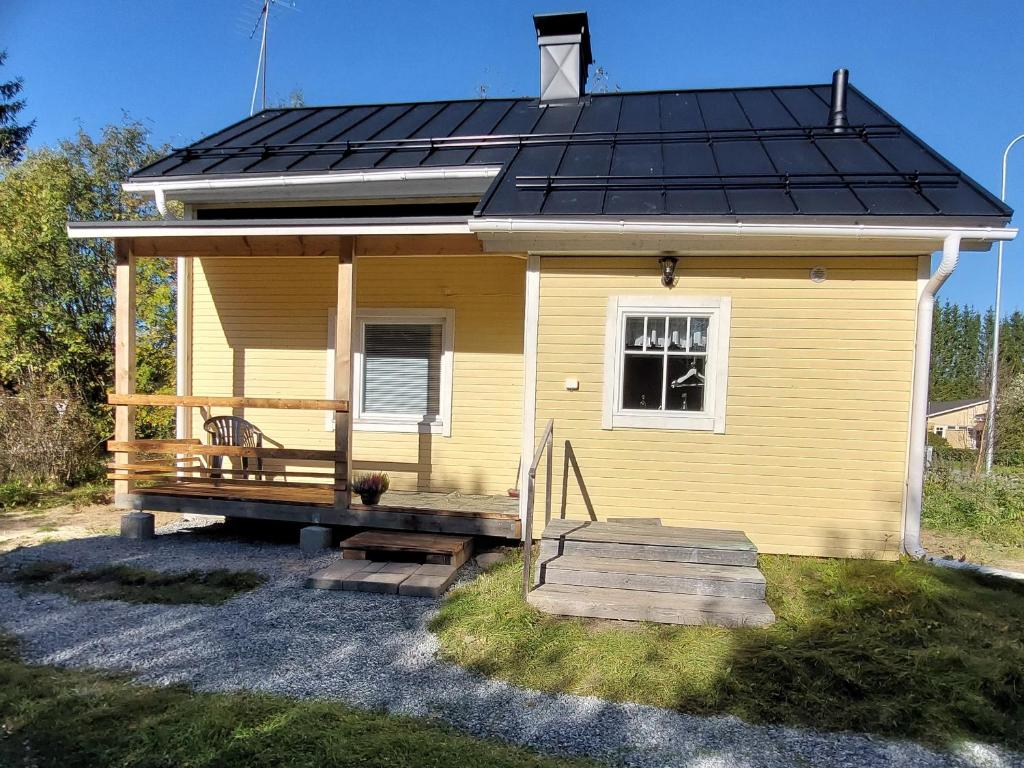 ein kleines gelbes Haus mit einem Solardach in der Unterkunft Grandma's cottage in Sotkamo