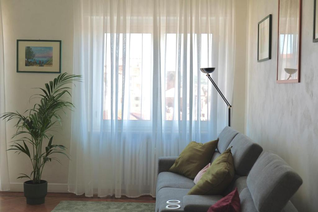 un salon avec un canapé et une grande fenêtre dans l'établissement Borgo Navile Apartment, à Turin