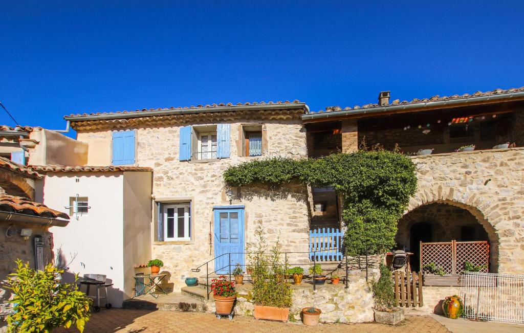 a large stone house with a blue door at Beautiful Home In Salles Sous Bois in Salles-sous-Bois