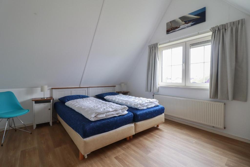 ein Schlafzimmer mit Bett, Schreibtisch und Fenster in der Unterkunft Beachvilla - 8 personen in Holle Poarte