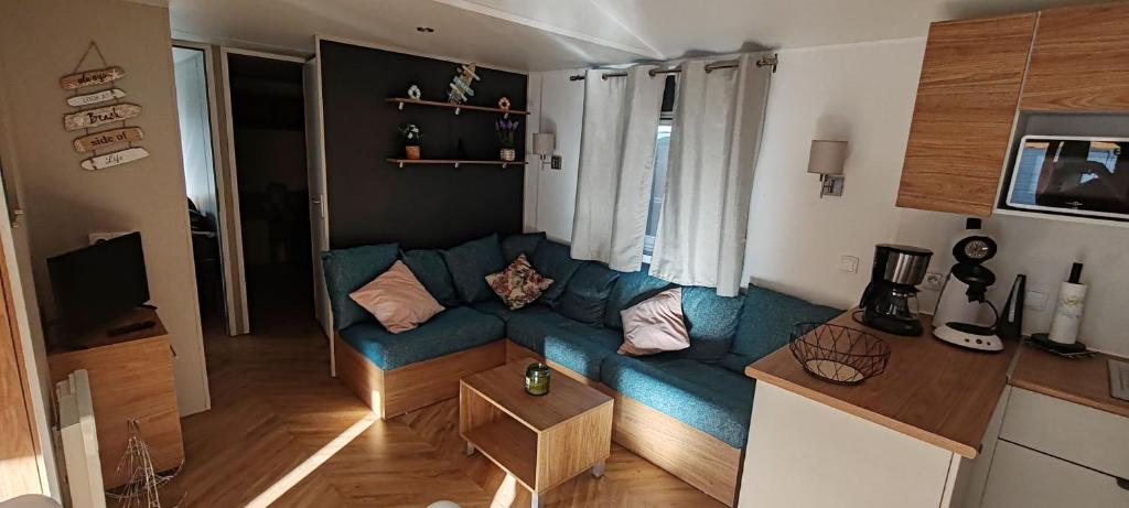 LA CARABASSE CP90 في فيا: غرفة معيشة مع أريكة زرقاء في مطبخ