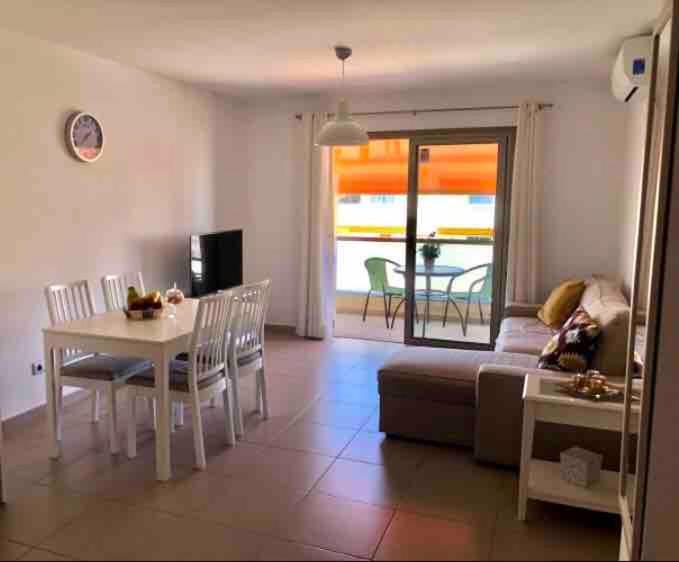una sala de estar con una mesa y un sofá en Alcalá Center Tenerife Canarias, en Guía de Isora