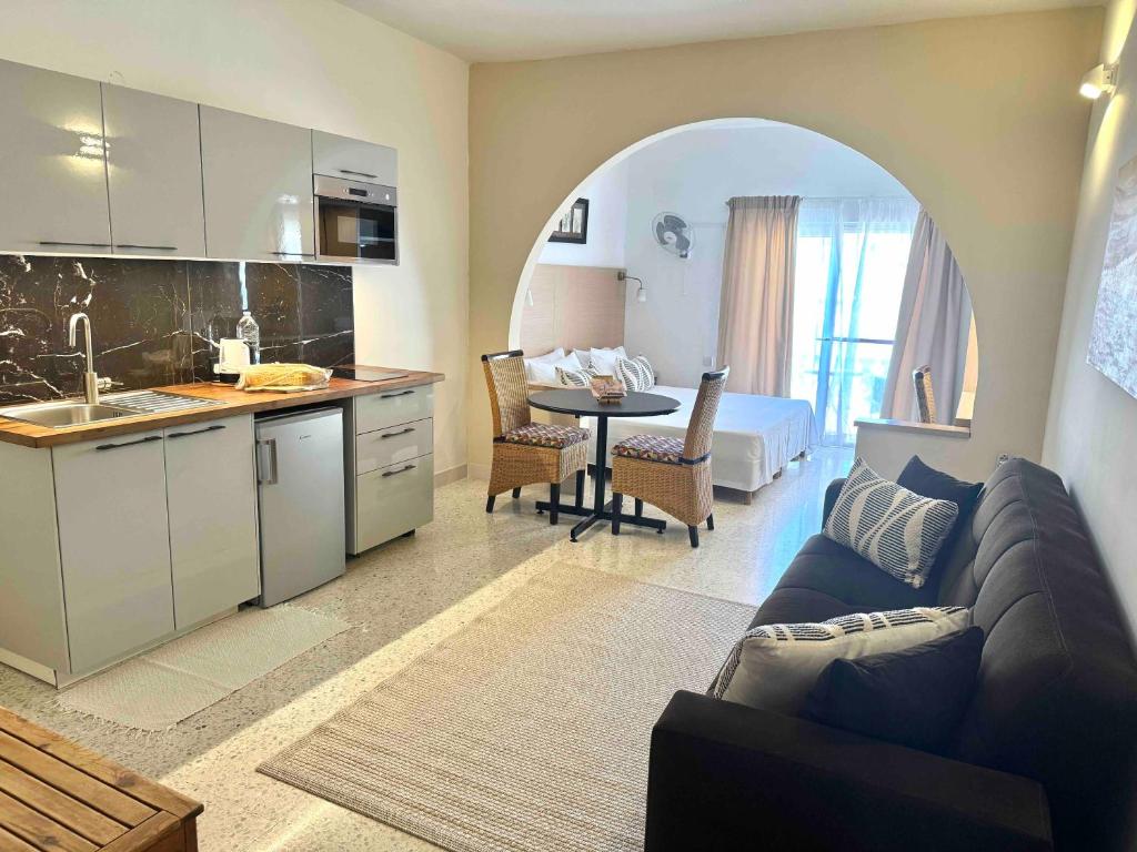 een keuken en woonkamer met een bank en een tafel bij Sands Apartments in St Paul's Bay