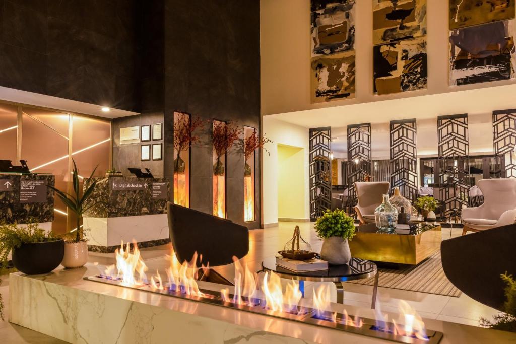 um lobby com uma lareira no meio em Gamma Ciudad Juarez em Ciudad Juárez